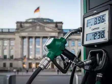Eine Zapfpistole mit einem digitalen Display, das einen gedeckelten Preis anzeigt. Im Hintergrund ist ein Gebäude des Bundesrates zu sehen. - Foto: über boerse-global.de