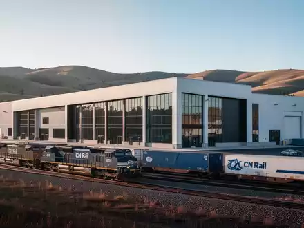 Eine moderne Industrieanlage mit einem CN Rail Zug im Vordergrund, der Effizienz und Logistik in Alberta symbolisiert. - Foto: über boerse-global.de