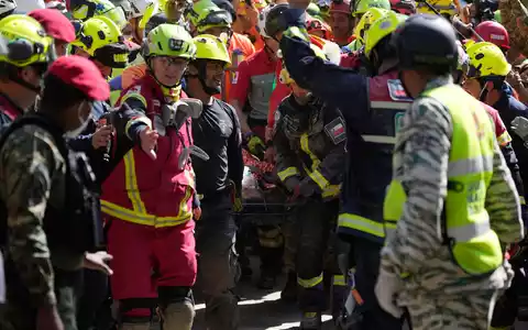 Rettungskräfte bergen einen Mann lebend aus den Trümmern eines eingestürzten Einkaufszentrums.  - Foto: Fernando Vergara/AP/dpa