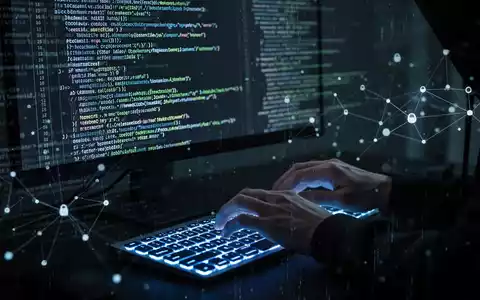 Hackerhände tippen auf Tastatur, Codezeilen auf Bildschirm, symbolisieren Cyberangriff. - Foto: über boerse-global.de