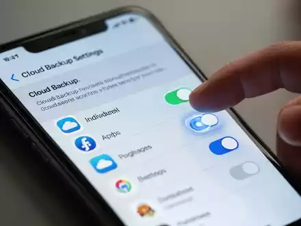 Nahaufnahme eines Smartphones, das eine Cloud-Backup-Einstellungsoberfläche mit Schaltern für einzelne Apps anzeigt. - Foto: über boerse-global.de