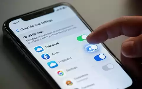 Nahaufnahme eines Smartphones, das eine Cloud-Backup-Einstellungsoberfläche mit Schaltern für einzelne Apps anzeigt. - Foto: über boerse-global.de
