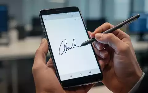Eine Hand hält ein Android-Smartphone, auf dem eine digitale Signatur erstellt wird, Symbol für digitales Dokumentenmanagement. - Foto: über boerse-global.de