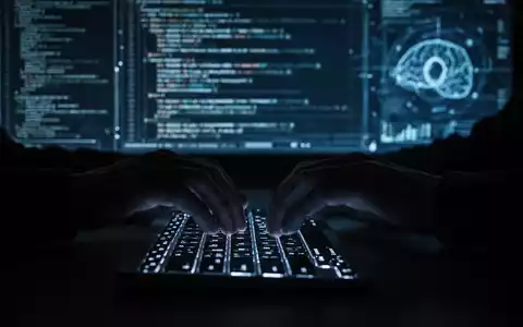 Eine dunkle Silhouette tippt auf einer leuchtenden Tastatur, im Hintergrund verschwommene digitale Daten und Codezeilen, die Cyber-Angriffe symbolisieren. - Foto: über boerse-global.de