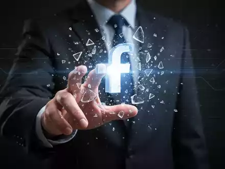 Hand greift nach leuchtendem, fragmentiertem Social-Media-Symbol, symbolisiert digitale Verletzlichkeit und Kampf um Account-Wiederherstellung. - Foto: über boerse-global.de