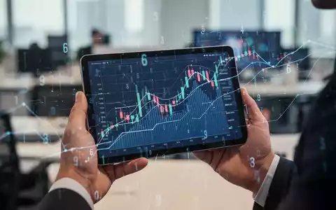 Hände halten ein Tablet mit Finanzgrafik und digitalen Overlays, die Steueränderungen darstellen. - Foto: über boerse-global.de