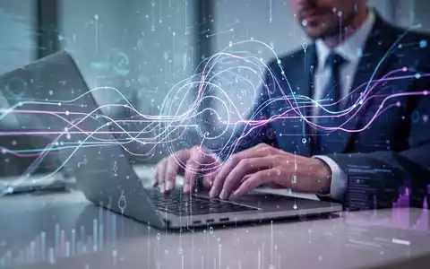 Leuchtendes, futuristisches Interface mit abstrakten Datenströmen über einer Person, die an einem Laptop arbeitet, symbolisiert KI-E-Mail-Verwaltung. - Foto: über boerse-global.de