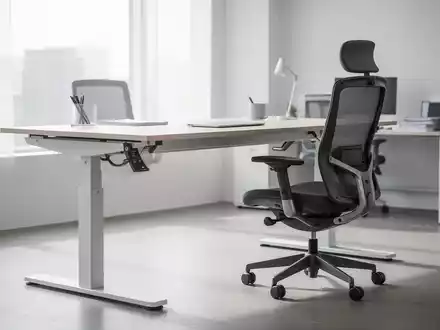 Ein höhenverstellbarer Schreibtisch und ein ergonomischer Bürostuhl in einem modernen, hellen Büro. Fokus auf die Anpassungsfunktionen. - Foto: über boerse-global.de