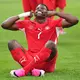 Bitte lächeln: Embolo jubelt im Sitzen. - Bild: Lindsey Wasson/AP/dpa