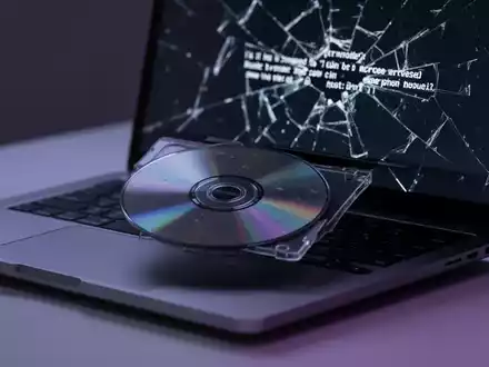 Nahaufnahme einer DVD, die in ein MacBook Pro eingelegt wird, mit Fehlermeldung auf dem Bildschirm. - Foto: über boerse-global.de