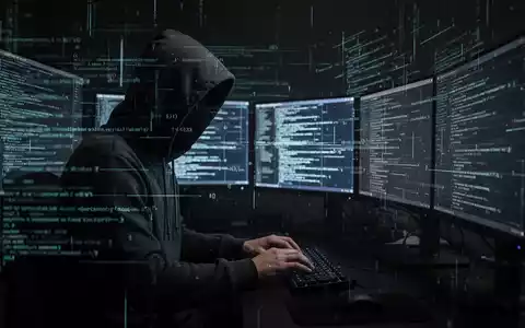 Eine Person im Hoodie, umgeben von Computermonitoren mit Code, symbolisiert Cyberkriminalität und Phishing. - Foto: über boerse-global.de