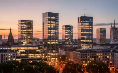 Moderne Bürogebäude in der Münchner Skyline bei Sonnenuntergang, beleuchtete Fenster, professionelle Fotografie. - Foto: über boerse-global.de