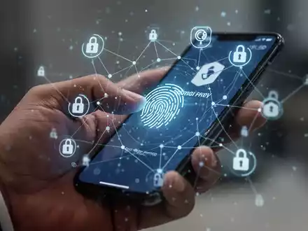 Nahaufnahme einer Hand, die ein Smartphone zur biometrischen Authentifizierung nutzt, mit überlagerten digitalen Sicherheitssymbolen. - Foto: über boerse-global.de