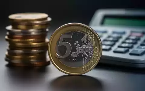 Nahaufnahme einer deutschen 5-Euro-Münze, im Hintergrund verschwommen weitere Münzen und ein Taschenrechner. - Foto: über boerse-global.de