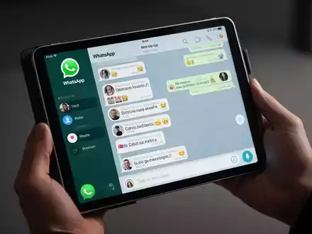 Eine Person hält ein iPad mit der WhatsApp-Chat-Oberfläche, Nachrichten und Symbole sichtbar. - Foto: über boerse-global.de