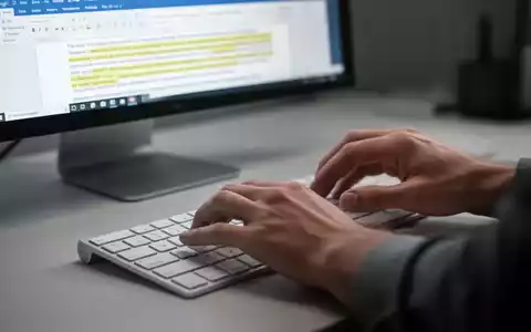 Nahaufnahme von Händen, die auf einer Tastatur tippen, mit einem Microsoft Word-Dokument im Hintergrund auf einem Bildschirm. - Foto: über boerse-global.de