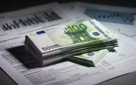 Ein Stapel Euro-Banknoten liegt auf einem offiziellen Dokument mit Finanzdiagrammen im Hintergrund, das Ausgaben und Schulden darstellt. - Foto: über boerse-global.de