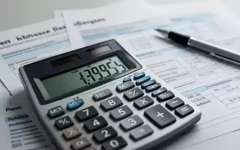 Ein Taschenrechner zeigt Finanzzahlen, im Hintergrund verschwommene Steuerdokumente und ein Stift. Symbolisiert neue Pauschbeträge und Steuerthemen. - Foto: über boerse-global.de