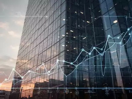 Eine moderne Bürofassade, überlagert mit stilisierten Bauplänen und Finanzgrafiken, die Immobilieninvestitionen und Steueränderungen darstellen. - Foto: über boerse-global.de