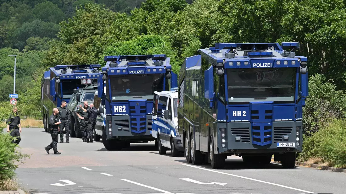 Wasserwerfer der Polizei stehen bereit, für den Fall, dass es zu Gewalt kommt. - Bild: Martin Schutt/dpa