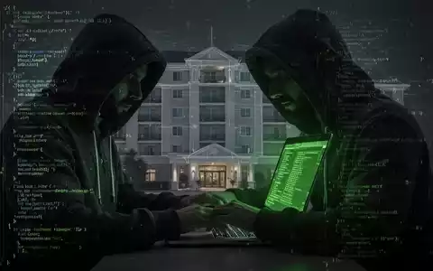 Person in Kapuzenjacke tippt auf Laptop, digitaler Code und Hotelumriss im Hintergrund, symbolisiert Cyberkriminalität gegen Hotels. - Foto: über boerse-global.de