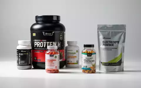 Eine Ansammlung von Nahrungsergänzungsmitteln, darunter Proteinpulver, Vitaminflaschen und Elektrolytpulver, auf einer weißen Oberfläche. - Foto: über boerse-global.de