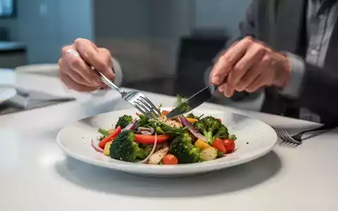 Nahaufnahme von Händen, die Besteck über einem Teller mit gesundem, farbenfrohem Essen halten, mit Bewegungsunschärfe, die langsames Essen andeutet. - Foto: über boerse-global.de