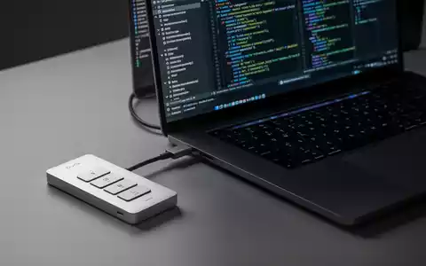 Schlankes, minimalistisches Drei-Tasten-Aluminium-Keypad 'Dune' an modernem MacBook Pro, zeigt KI-gestützte Arbeitsabläufe. - Foto: über boerse-global.de