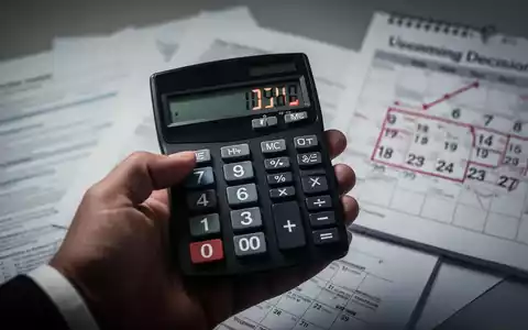 Eine Hand hält einen Taschenrechner, der negative Zahlen anzeigt, mit unscharfen Finanzdokumenten und einem Kalender im Hintergrund. - Foto: über boerse-global.de
