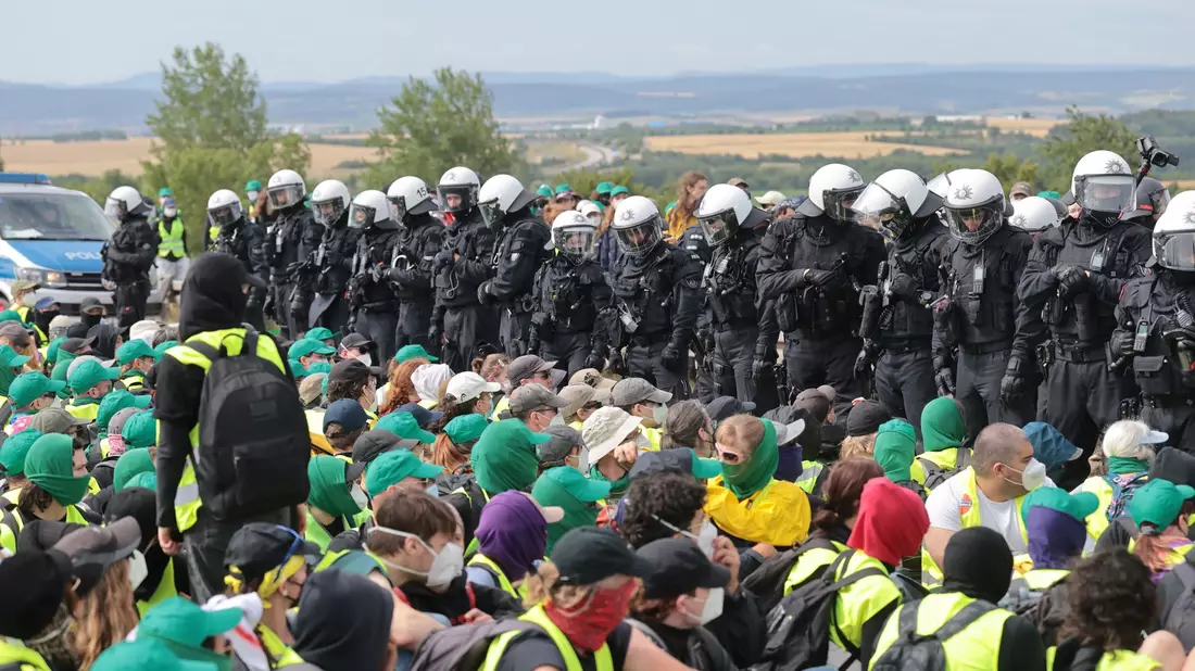 Eine Sitzblockade auf der Autobahn 71 - Polizisten umringen die Demonstranten. - Bild: Michael Reichel/dpa