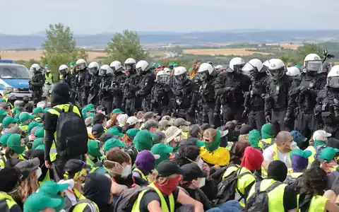 Eine Sitzblockade auf der Autobahn 71 - Polizisten umringen die Demonstranten. - Foto: Michael Reichel/dpa