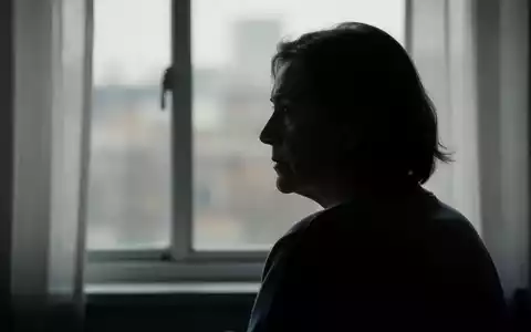 Eine einzelne, silhouettierte Person schaut nachdenklich aus einem Fenster, die Umgebung ist unscharf. Die Szene wirkt ruhig und kontemplativ. - Foto: über boerse-global.de