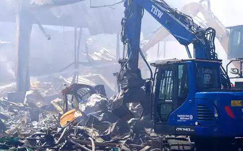 Einsatzkräfte des Technischen Hilfswerks (THW) beseitigen mit einem Bagger Schutt nach einem Feuer in einem Gewerbegebiet in Stuttgart. - Foto: Enrique Kaczor/dpa