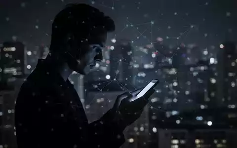 Silhouette blickt auf Smartphone mit digitalem Netz-Overlay vor verschwommener, dunkler Stadtlandschaft. - Foto: über boerse-global.de