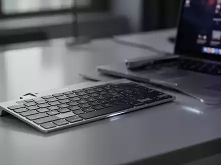 Schlankes, minimalistisches Drei-Tasten-Aluminium-USB-C-Keypad (Dune-Zubehör) neben modernem MacBook Pro auf poliertem Schreibtisch. - Foto: über boerse-global.de
