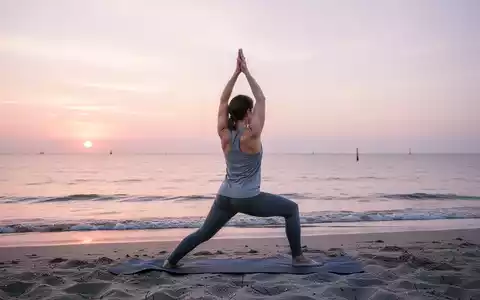 Eine Person macht Yoga in einer friedlichen Pose am Strand von Warnemünde bei Sonnenaufgang mit Blick auf die Ostsee. - Foto: über boerse-global.de
