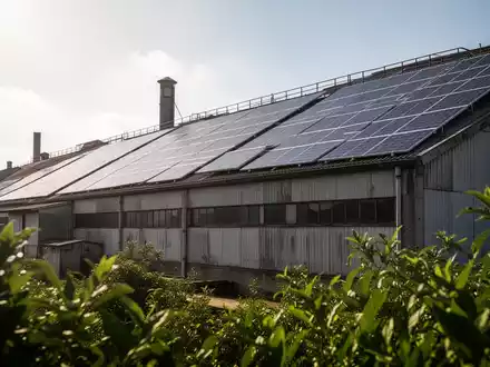 Solarmodule auf dem Dach einer Textilfabrik, symbolisieren Nachhaltigkeit und Eigenstromerzeugung in der Industrie. - Foto: über boerse-global.de
