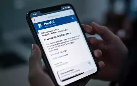 Nahaufnahme eines Smartphone-Bildschirms mit betrügerischer PayPal-Phishing-E-Mail, unscharfe Hände halten das Telefon. - Foto: über boerse-global.de