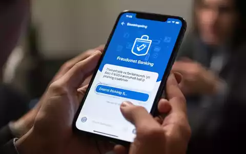 Nahaufnahme eines Smartphones, das eine betrügerische Banking-App oder Phishing-Nachricht anzeigt, mit unscharfen Händen im Hintergrund. - Foto: über boerse-global.de