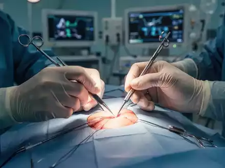 Nahaufnahme der Hände eines Chirurgen bei einer minimalinvasiven Operation mit leuchtenden chirurgischen Instrumenten. - Foto: über boerse-global.de