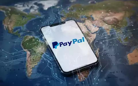 Ein Smartphone mit PayPal-Logo, digitale Linien verbinden sich mit einer unscharfen Karte von Asien und Ostafrika im Hintergrund. - Foto: über boerse-global.de