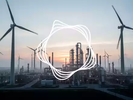 Eine weitläufige industrielle Landschaft bei Sonnenaufgang mit Windturbinen und einer Elektrolyseanlage, die saubere Energieerzeugung symbolisiert. - Foto: über boerse-global.de