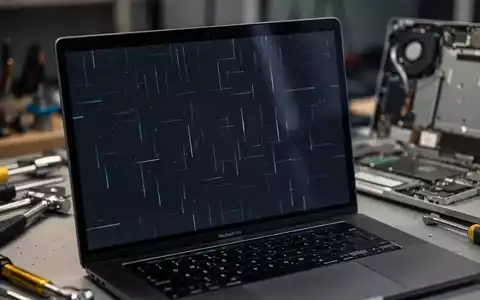 Nahaufnahme eines MacBook Pro-Bildschirms mit feinen flackernden Linien, Reparaturwerkzeuge unscharf im Hintergrund. - Foto: über boerse-global.de