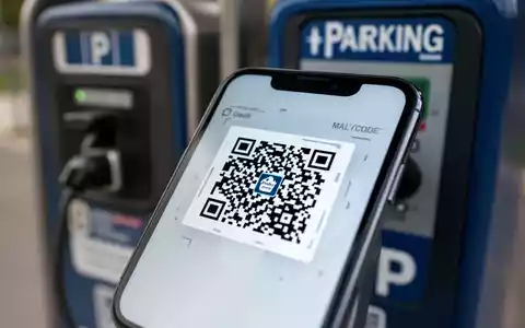 Ein Smartphone-Bildschirm zeigt einen schädlichen QR-Code auf einem Parkscheinautomaten, der eine Quishing-Cyberbedrohung symbolisiert. - Foto: über boerse-global.de