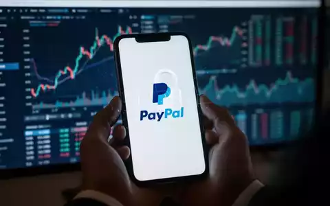 Handy mit PayPal-Logo und Sicherheitsschloss, Finanzcharts im Hintergrund. - Foto: über boerse-global.de