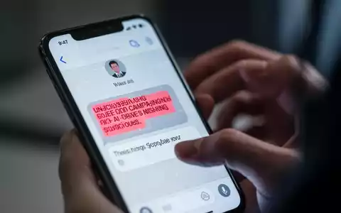Ein Smartphone-Bildschirm zeigt eine betrügerische SMS, während eine verschwommene Hand im Hintergrund auf dem Telefon tippt. - Foto: über boerse-global.de