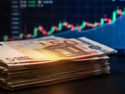 Ein Stapel Euro-Banknoten mit unscharfem, aufwärts gerichteten Börsen-Chart im Hintergrund, der Anleihen und Finanzwachstum symbolisiert. - Foto: über boerse-global.de
