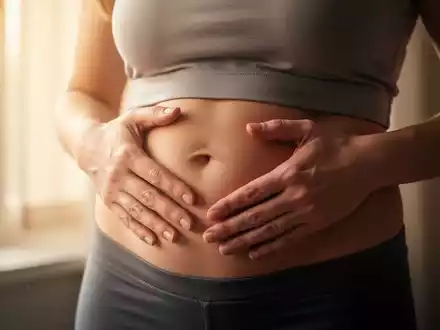Nahaufnahme des Bauches einer Frau, die ihre Hände sanft darauflegt, um Sorge und Gesundheitsbewusstsein auszudrücken. - Foto: über boerse-global.de