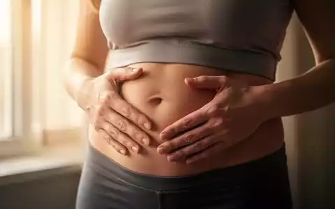 Nahaufnahme des Bauches einer Frau, die ihre Hände sanft darauflegt, um Sorge und Gesundheitsbewusstsein auszudrücken. - Foto: über boerse-global.de