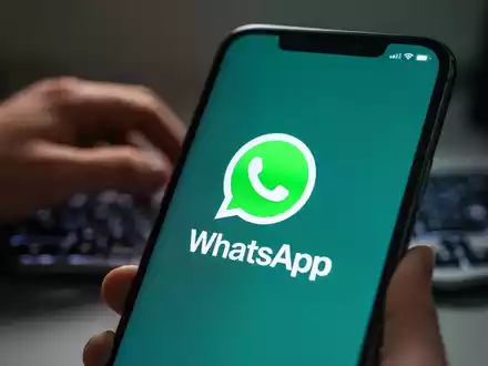 Smartphone-Bildschirm mit WhatsApp-Logo und unscharfer tippender Hand, Symbol für digitale Kommunikation und Datenschutzbedenken. - Foto: über boerse-global.de